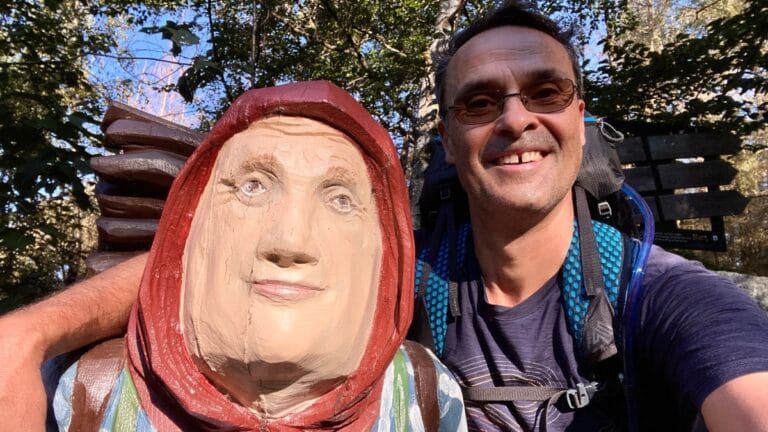 DeWandelaar zittend bij het Kiepenfrau-monument op de Harzer-Hexen-Stieg in de Harz