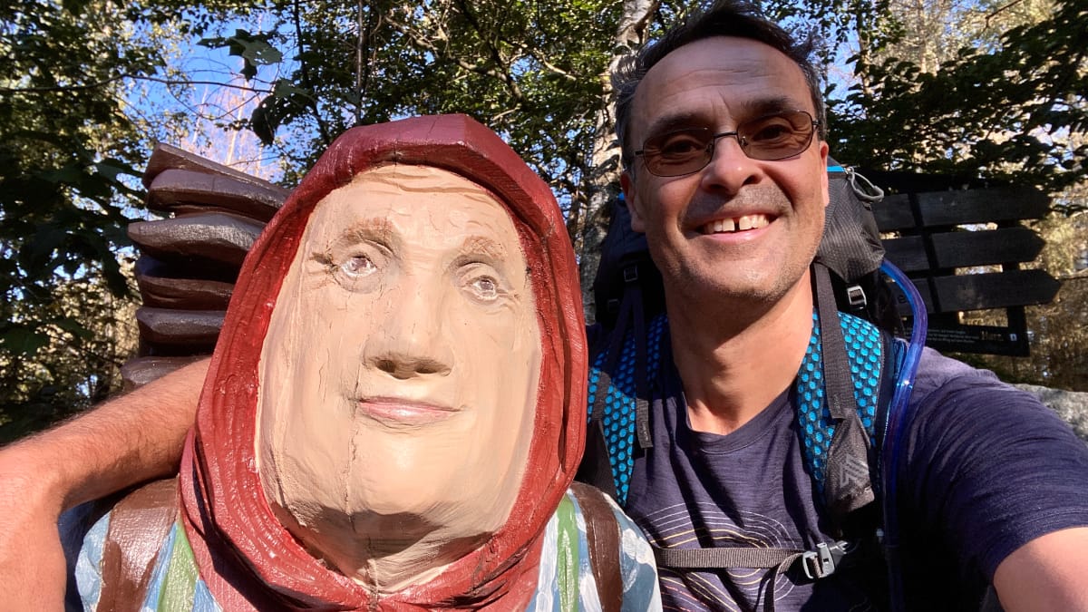 DeWandelaar zittend bij het Kiepenfrau-monument op de Harzer-Hexen-Stieg in de Harz