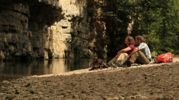 Meerdaagse wandelaars zittend aan de Wutachrivier in de Wutachkloof op de Schluchtensteig in het Zwarte Woud