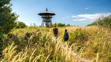 Twee wandelaars lopen richting de Eggeturm op de Preußischer Velmerstot