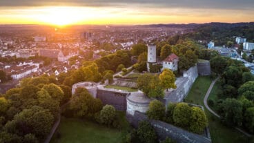 Een luchtbeeld van Bielefeld bij zonsopgang met de Sparrenberg op de voorgrond